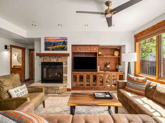 Step into luxury with this stunning living room, featuring a cozy fireplace and a sleek entertainment center.