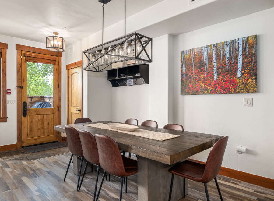 This stunning dining room features a rustic wooden table, perfect for hosting gatherings.