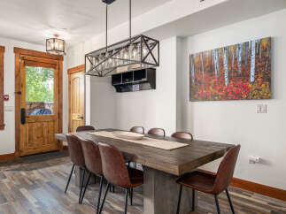 This stunning dining room features a rustic wooden table, perfect for hosting gatherings.