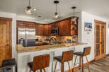 This stunning kitchen boasts beautiful wooden cabinetry, stainless steel appliances, and a granite countertop, creating a warm and inviting atmosphere.