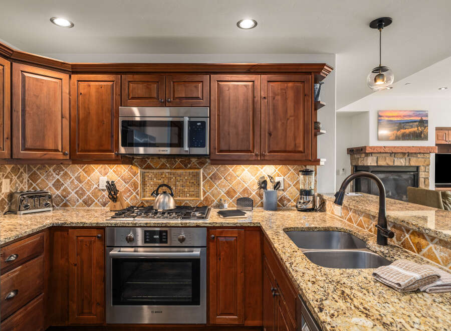 This stunning kitchen boasts rich wooden cabinetry, stainless steel appliances, and a beautiful granite countertop.
