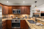 This stunning kitchen boasts rich wooden cabinetry, stainless steel appliances, and a beautiful granite countertop.
