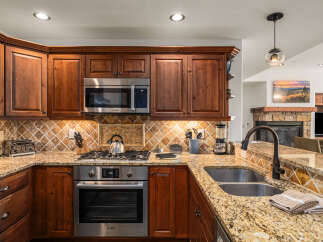 This stunning kitchen boasts rich wooden cabinetry, stainless steel appliances, and a beautiful granite countertop.