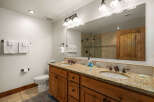 This stunning bathroom boasts a luxurious double vanity with a granite countertop, offering ample space for your daily routines.