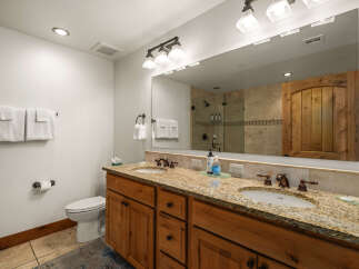 This stunning bathroom boasts a luxurious double vanity with a granite countertop, offering ample space for your daily routines.