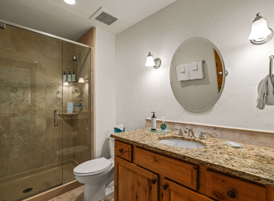 This stunning bathroom features a luxurious granite countertop and a stylish vanity, creating an elegant and functional space.