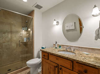 This stunning bathroom features a luxurious granite countertop and a stylish vanity, creating an elegant and functional space.
