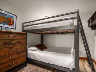 This cozy bedroom features a stylish bunk bed, perfect for accommodating guests or family members.