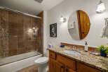 This stunning bathroom boasts a luxurious feel with its granite countertops and rich wooden cabinetry.