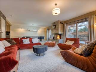 Experience luxury living in this stunning property, featuring a cozy living room with a fireplace and plush seating.