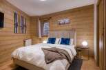 This cozy bedroom features a rustic wooden wall design, creating a warm and inviting atmosphere.