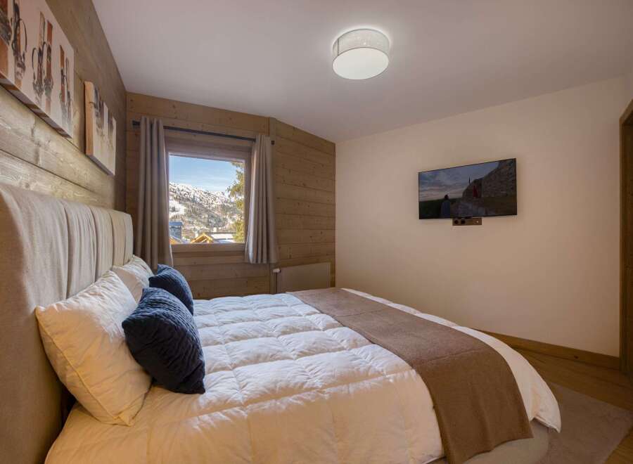 This cozy bedroom features a comfortable bed with plush pillows and a warm, inviting atmosphere.
