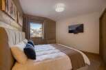 This cozy bedroom features a comfortable bed with plush pillows and a warm, inviting atmosphere.