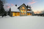 This stunning stone house is nestled in a winter wonderland, offering a serene and picturesque setting.
