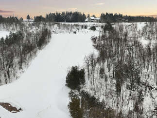This stunning property offers a serene winter landscape, perfect for those seeking a peaceful retreat.