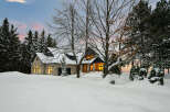 This stunning property showcases a beautiful stone house nestled in a winter wonderland.