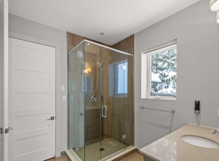 Step into luxury with this stunning bathroom featuring a modern glass shower and elegant vanity.