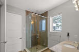 Step into luxury with this stunning bathroom featuring a modern glass shower and elegant vanity.