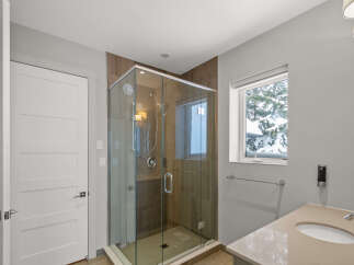 Step into luxury with this stunning bathroom featuring a modern glass shower and elegant vanity.