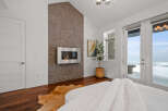 Experience luxury in this stunning bedroom featuring a modern fireplace and a unique accent wall.