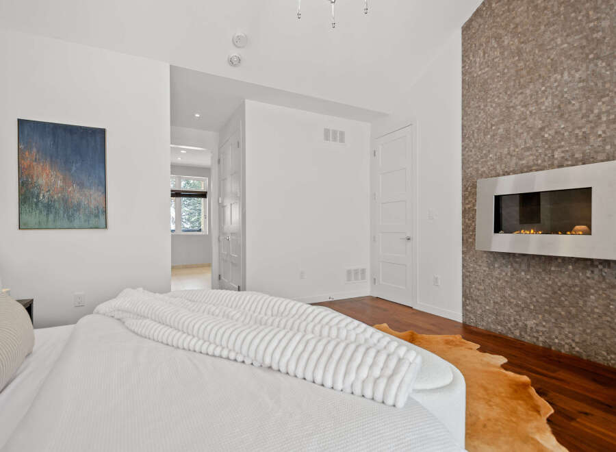 This stunning bedroom boasts a modern fireplace, adding warmth and sophistication to the space.