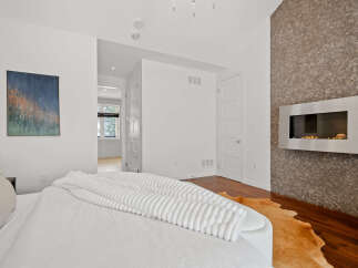 This stunning bedroom boasts a modern fireplace, adding warmth and sophistication to the space.
