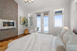 Experience luxury in this stunning bedroom featuring a modern fireplace and a cozy bed.