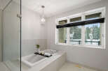 This luxurious bathroom boasts a spa-like ambiance with its sleek design and high-end finishes.