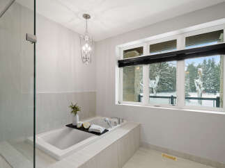 This luxurious bathroom boasts a spa-like ambiance with its sleek design and high-end finishes.