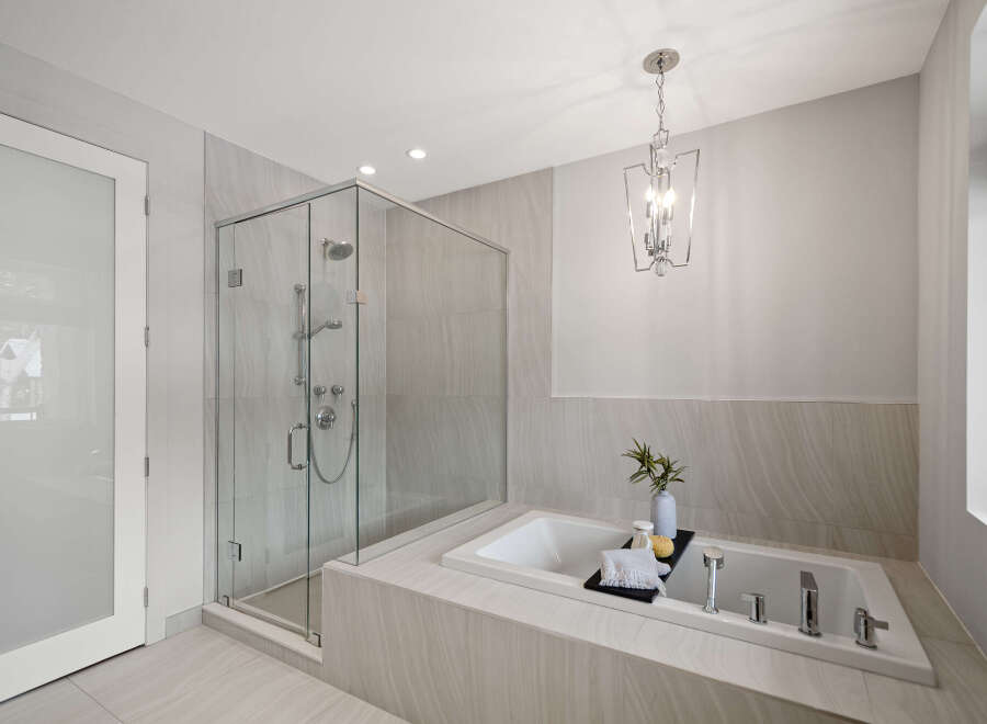 Step into luxury with this stunning bathroom featuring a sleek glass shower and a relaxing soaking tub.