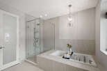 Step into luxury with this stunning bathroom featuring a sleek glass shower and a relaxing soaking tub.