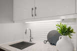 This modern kitchen boasts sleek white cabinetry and a stylish stainless steel faucet.