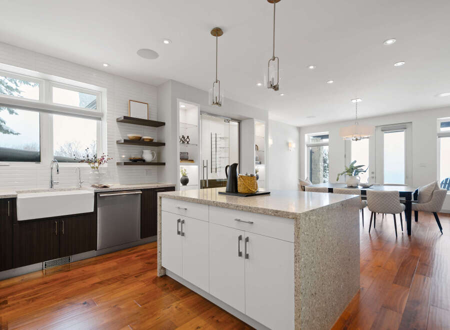This stunning kitchen boasts a modern design with sleek white cabinetry and a spacious island, perfect for both cooking and entertaining.
