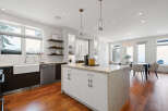 This stunning kitchen boasts a modern design with sleek white cabinetry and a spacious island, perfect for both cooking and entertaining.