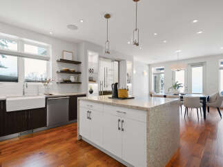 This stunning kitchen boasts a modern design with sleek white cabinetry and a spacious island, perfect for both cooking and entertaining.