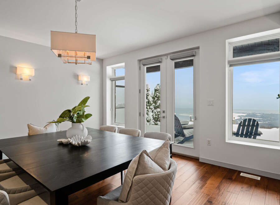 This stunning dining room boasts a modern aesthetic with a sleek, dark wood dining table and elegant seating.