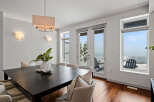 This stunning dining room boasts a modern aesthetic with a sleek, dark wood dining table and elegant seating.