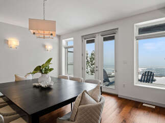 This stunning dining room boasts a modern aesthetic with a sleek, dark wood dining table and elegant seating.