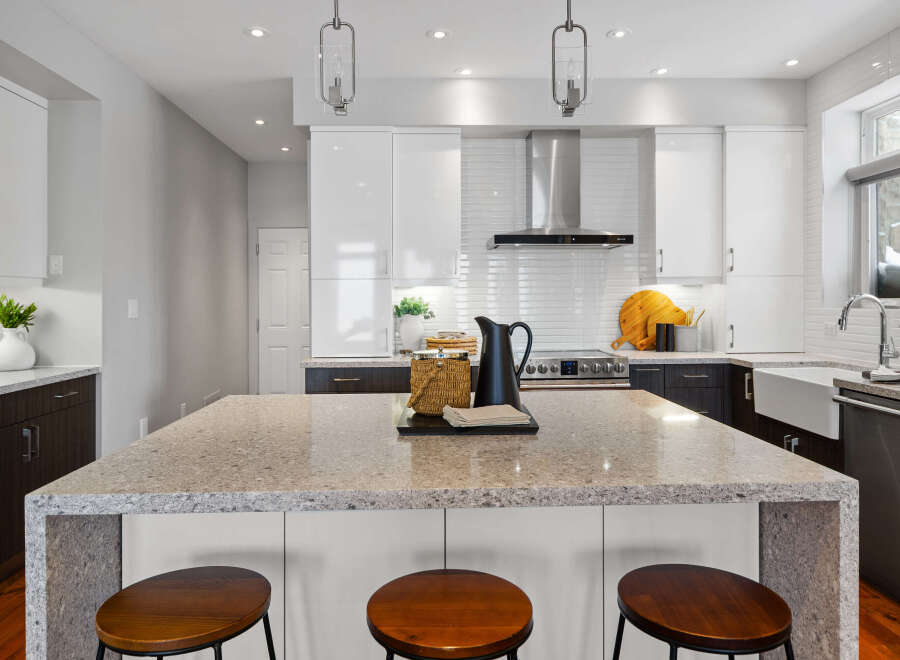 This stunning kitchen boasts a modern design with sleek white cabinetry and a spacious island, perfect for entertaining.