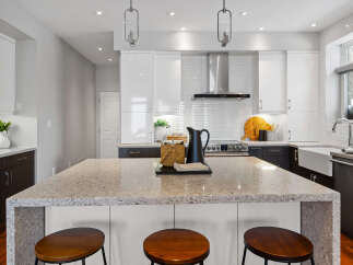 This stunning kitchen boasts a modern design with sleek white cabinetry and a spacious island, perfect for entertaining.