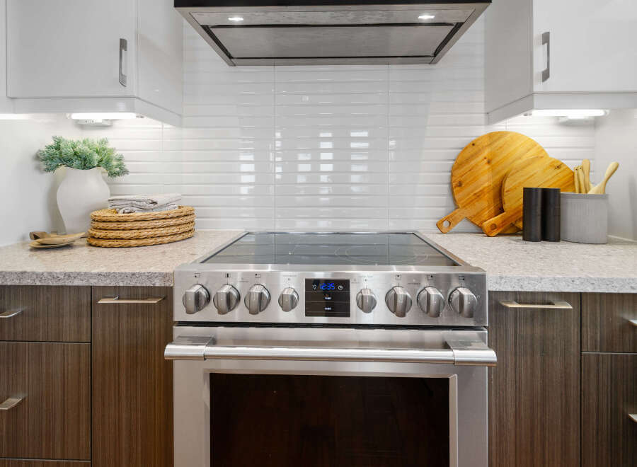 This modern kitchen boasts sleek stainless steel appliances, including a stylish oven with a digital display.