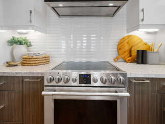This modern kitchen boasts sleek stainless steel appliances, including a stylish oven with a digital display.