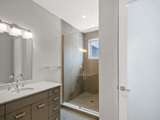 Step into luxury with this stunning bathroom! Featuring a modern vanity, a sleek glass shower, and elegant lighting, this space is designed for both style and functionality.
