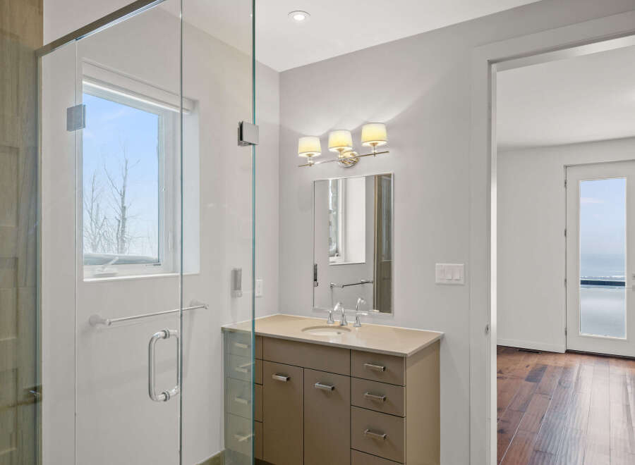 Step into luxury with this stunning bathroom featuring a sleek glass shower enclosure and a modern vanity.