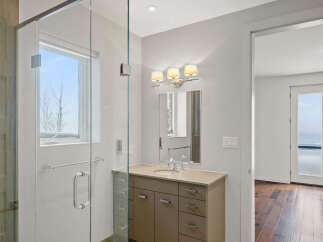 Step into luxury with this stunning bathroom featuring a sleek glass shower enclosure and a modern vanity.