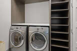 This laundry room features a modern design with a sleek countertop and ample storage space.
