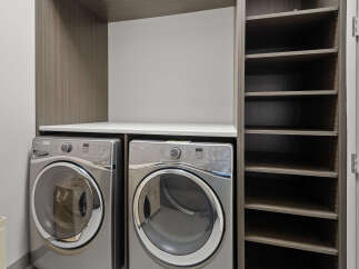 This laundry room features a modern design with a sleek countertop and ample storage space.