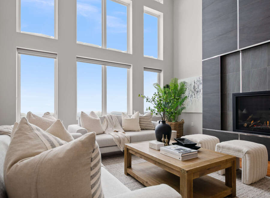 Experience luxury living in this stunning property, featuring a spacious living room with high ceilings and large windows that flood the space with natural light.