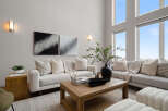 Experience luxury living in this stunning property, featuring a spacious living room with high ceilings and abundant natural light.