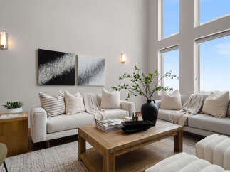 Experience luxury living in this stunning property, featuring a spacious living room with high ceilings and abundant natural light.